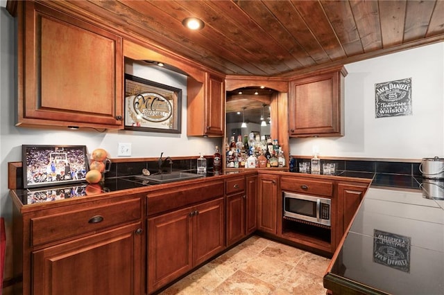 16805 266th Rd, Atchison, KS 66002 - kitchen with stainless steel microwave, a sink, brown cabinetry, ornamental molding, and light stone finish flooring