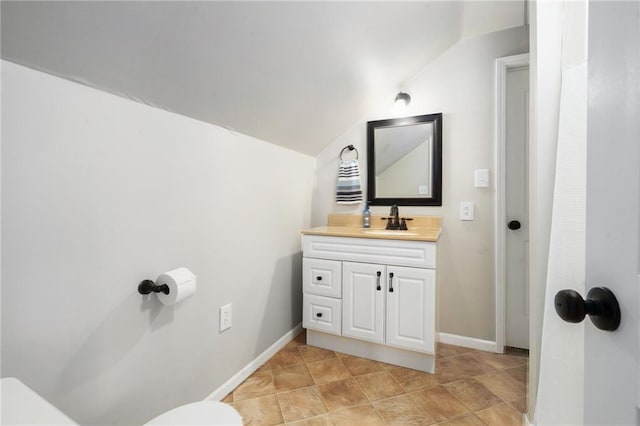 16805 266th Rd, Atchison, KS 66002 - bathroom featuring toilet, vanity, vaulted ceiling, and baseboards