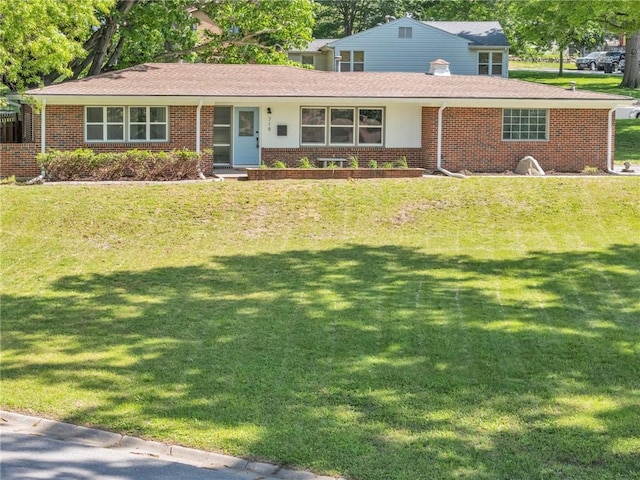 view of front of property with brick siding, a front yard, and roof with shingles