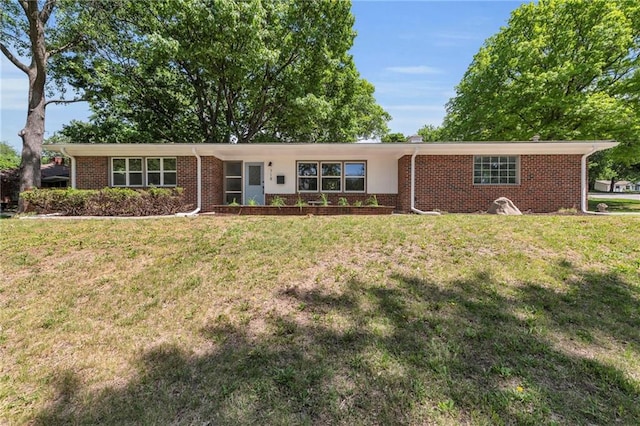 ranch-style house featuring brick siding and a front yard
