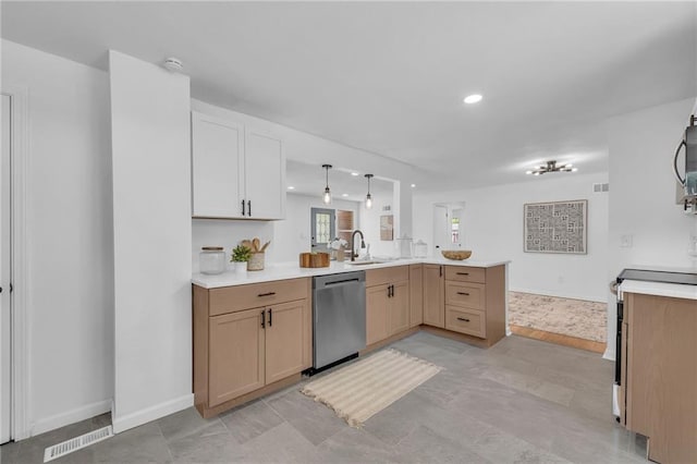 kitchen featuring appliances with stainless steel finishes, a peninsula, light countertops, a sink, and recessed lighting