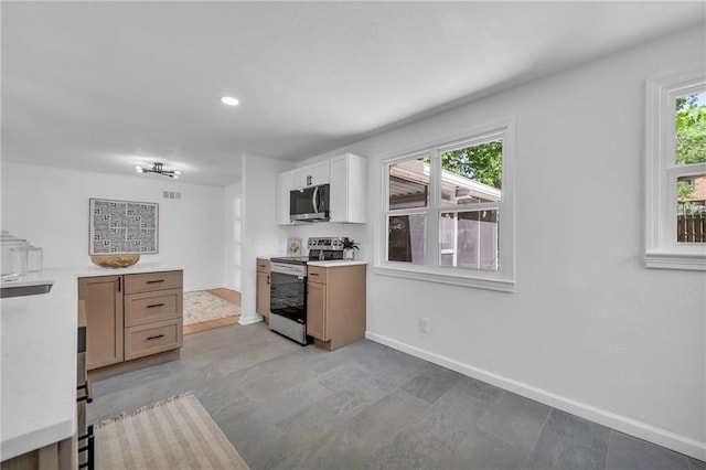kitchen with stainless steel appliances, light countertops, baseboards, healthy amount of natural light, and recessed lighting