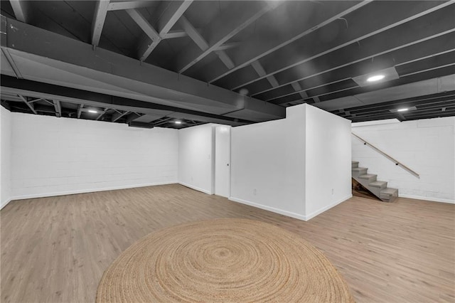 finished basement featuring wood finished floors, stairs, and baseboards