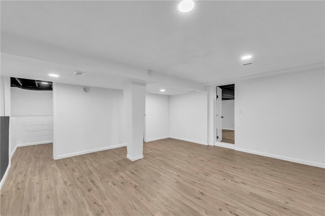 finished basement featuring light wood-style floors, baseboards, and recessed lighting
