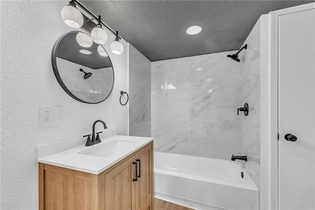 full bathroom with a textured wall, bathtub / shower combination, vanity, and a textured ceiling