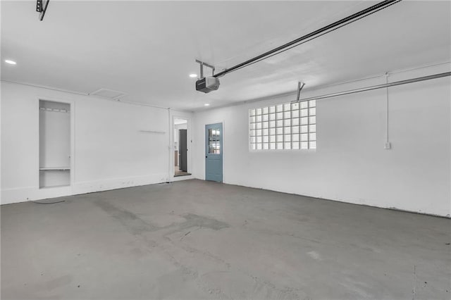 garage with a garage door opener and recessed lighting