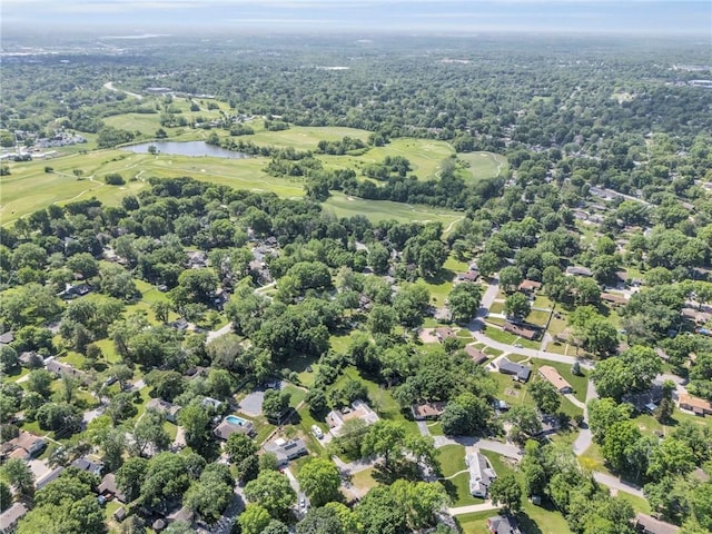 aerial view of property and surrounding area featuring a nearby body of water and a golf course