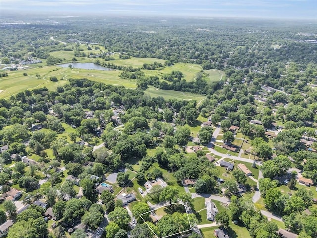drone / aerial view of a nearby body of water and a golf course