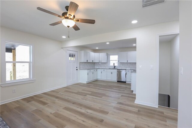15608 E 267th St, Harrisonville, MO 64701 - kitchen with stainless steel dishwasher, a sink, white cabinetry, tasteful backsplash, and light wood finished floors