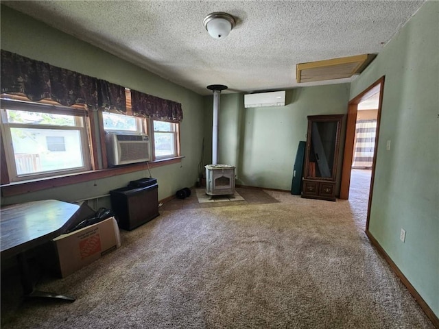 201 2nd St, Uniontown, KS 66779 - bedroom featuring a wood stove, carpet, cooling unit, a textured ceiling, and a wall unit AC