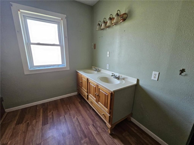 201 2nd St, Uniontown, KS 66779 - bathroom featuring wood finished floors, baseboards, and double vanity