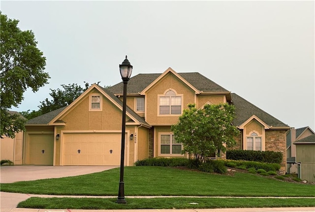 14650 NW 66th Ter, Parkville, MO 64152 - view of front of house with a front lawn, concrete driveway, stucco siding, and an attached garage