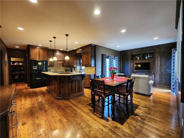 14650 NW 66th Ter, Parkville, MO 64152 - kitchen featuring black refrigerator with ice dispenser, light countertops, dark wood-type flooring, a center island, and a sink