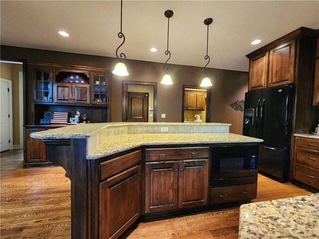 14650 NW 66th Ter, Parkville, MO 64152 - kitchen featuring black appliances, glass insert cabinets, light wood-type flooring, a kitchen island, and hanging light fixtures