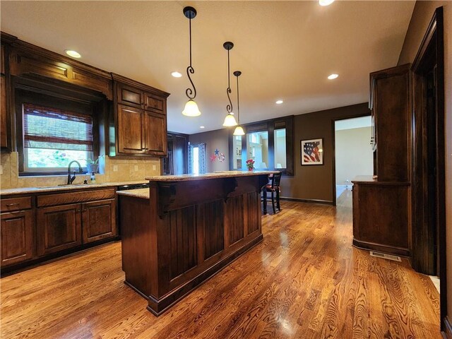 14650 NW 66th Ter, Parkville, MO 64152 - kitchen with a sink, recessed lighting, light countertops, decorative backsplash, and light wood finished floors