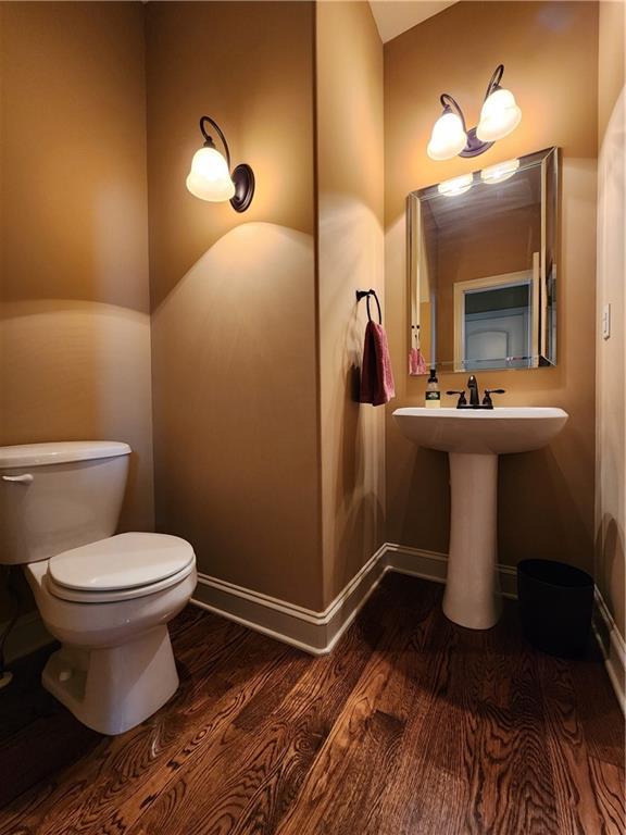 14650 NW 66th Ter, Parkville, MO 64152 - half bathroom featuring wood finished floors, toilet, baseboards, and a sink