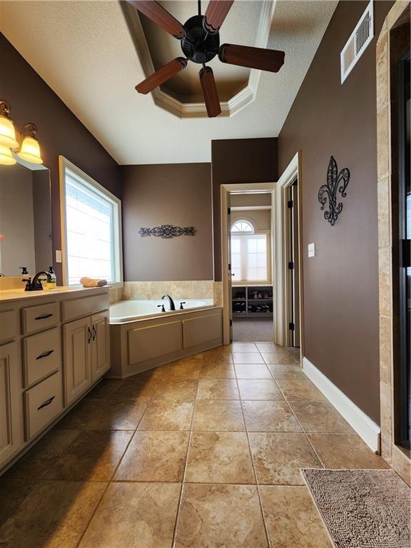 14650 NW 66th Ter, Parkville, MO 64152 - full bathroom with a raised ceiling, a garden tub, ceiling fan, vanity, and tile patterned floors