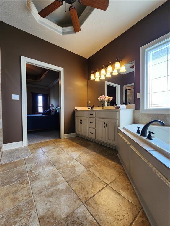 14650 NW 66th Ter, Parkville, MO 64152 - full bathroom with double vanity, ceiling fan, a garden tub, and crown molding