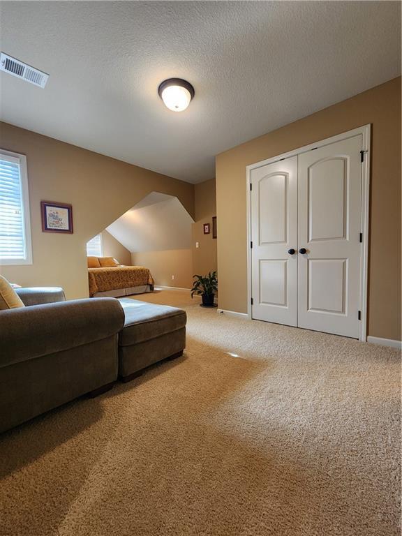 14650 NW 66th Ter, Parkville, MO 64152 - carpeted living area with baseboards and a textured ceiling