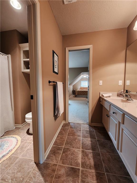 14650 NW 66th Ter, Parkville, MO 64152 - bathroom with vanity, toilet, baseboards, and a textured ceiling