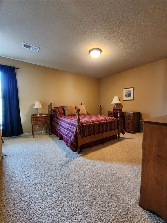 14650 NW 66th Ter, Parkville, MO 64152 - bedroom with light colored carpet and a textured ceiling