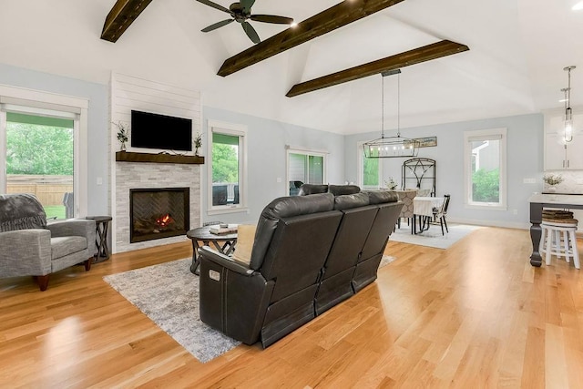 4403 Goldfield St, Lawrence, KS 66049 - living area featuring ceiling fan, light wood-style floors, beamed ceiling, a fireplace, and plenty of natural light