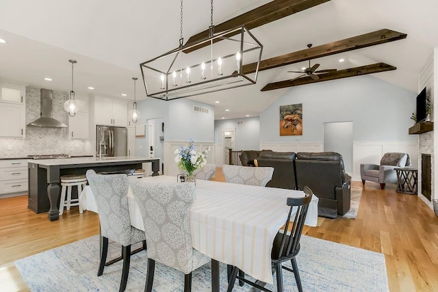 4403 Goldfield St, Lawrence, KS 66049 - dining area with light wood-style floors, beam ceiling, a ceiling fan, high vaulted ceiling, and wainscoting