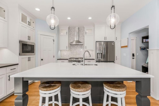 4403 Goldfield St, Lawrence, KS 66049 - kitchen featuring appliances with stainless steel finishes, wall chimney exhaust hood, a sink, white cabinetry, and light wood-type flooring