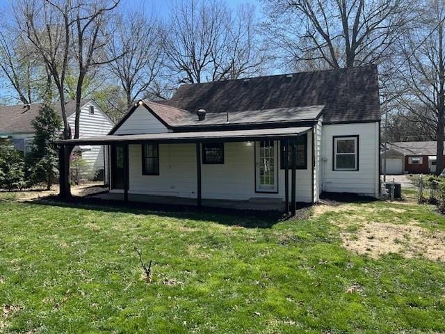 rear view of house with a lawn, roof with shingles, and covered porch