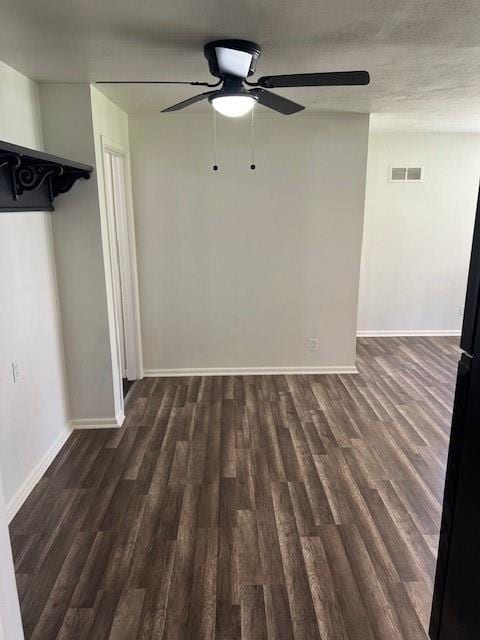 unfurnished living room featuring dark wood-style flooring, ceiling fan, and baseboards