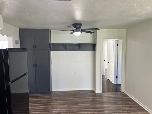 kitchen with freestanding refrigerator, a ceiling fan, dark wood-style flooring, baseboards, and a textured ceiling