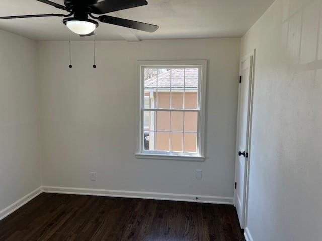 unfurnished room with dark wood-style floors, a ceiling fan, and baseboards