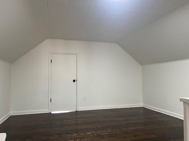additional living space featuring vaulted ceiling, wood finished floors, and baseboards
