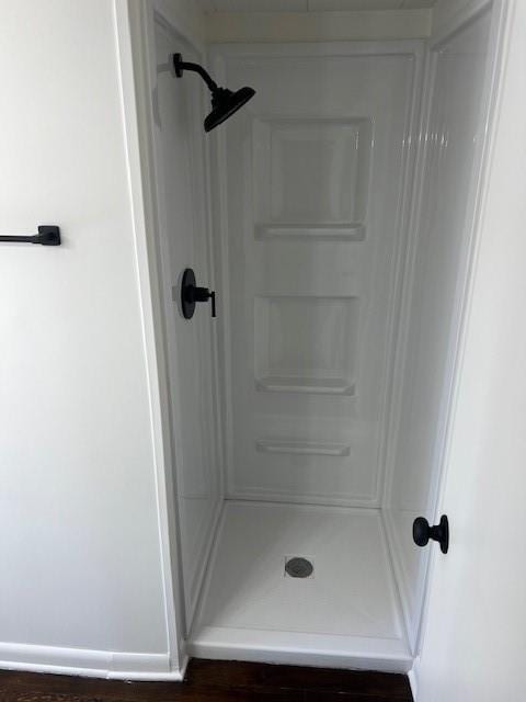 full bath featuring a shower stall and wood finished floors