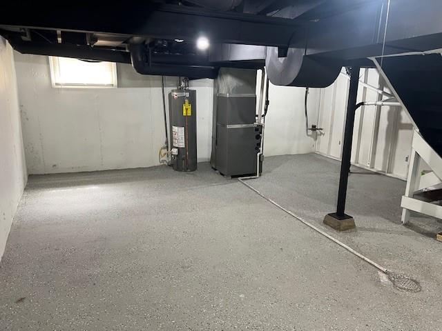basement featuring water heater and heating unit
