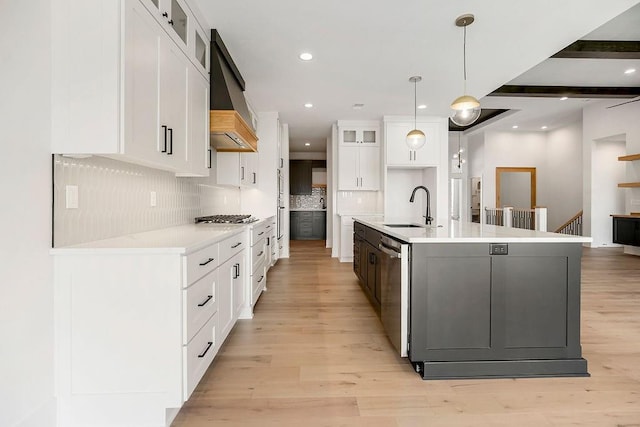 kitchen with a sink, appliances with stainless steel finishes, backsplash, glass insert cabinets, and recessed lighting