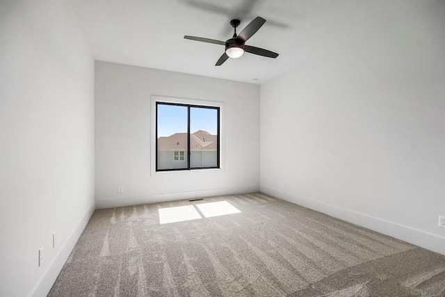 spare room featuring carpet floors, ceiling fan, and baseboards