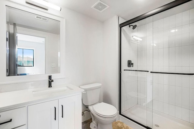 bathroom with toilet, a shower stall, and vanity