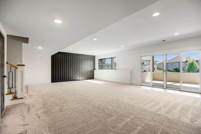 unfurnished living room with carpet floors, recessed lighting, stairway, and baseboards