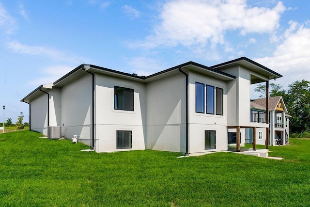 back of property with a lawn and central air condition unit