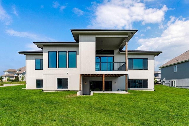back of house with a yard and a balcony