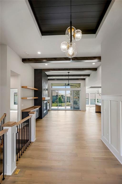 hallway with light wood-type flooring, a chandelier, beamed ceiling, and recessed lighting