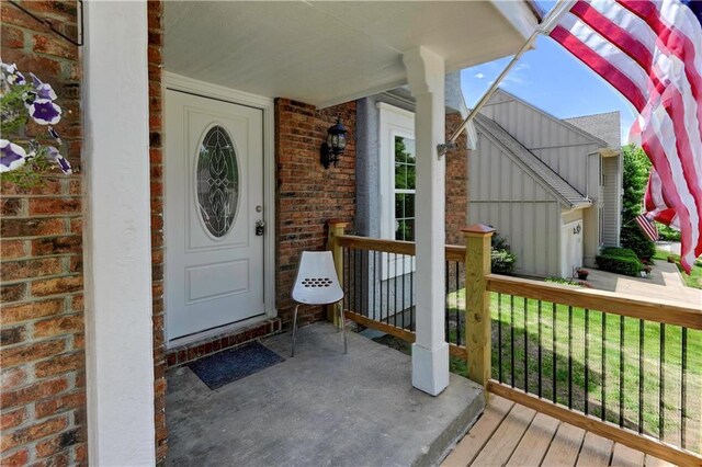 16253 W Briarwood Ct, Olathe, KS 66062 - view of exterior entry featuring brick siding, a porch, a garage, and board and batten siding