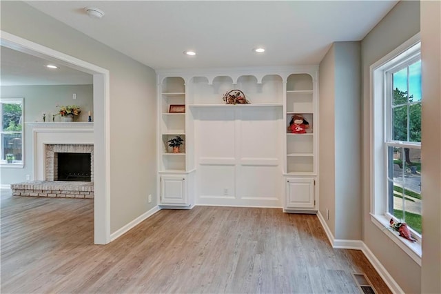 16253 W Briarwood Ct, Olathe, KS 66062 - unfurnished dining area with wood finished floors, recessed lighting, baseboards, and a brick fireplace