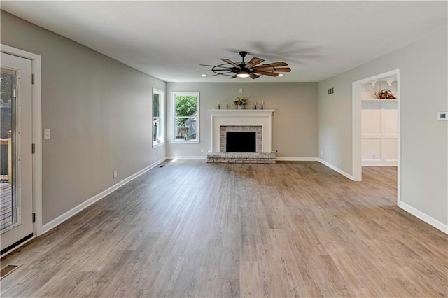 16253 W Briarwood Ct, Olathe, KS 66062 - unfurnished living room featuring ceiling fan, wood finished floors, a brick fireplace, and baseboards