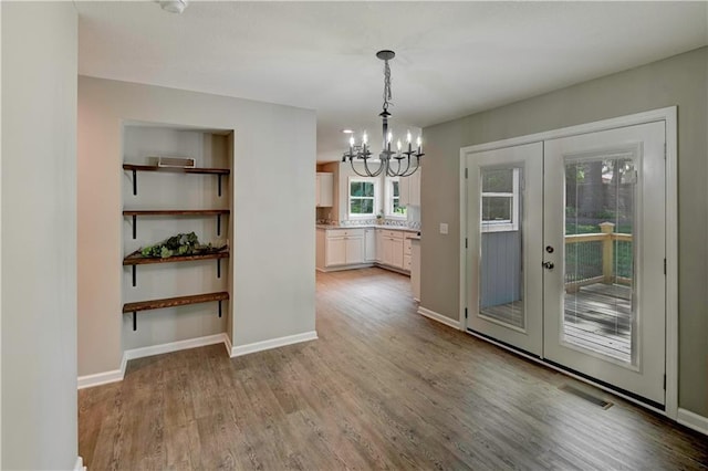 16253 W Briarwood Ct, Olathe, KS 66062 - unfurnished dining area featuring a chandelier, wood finished floors, french doors, and baseboards