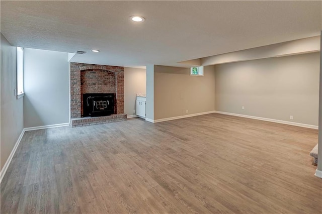16253 W Briarwood Ct, Olathe, KS 66062 - unfurnished living room with wood finished floors, baseboards, a brick fireplace, and recessed lighting