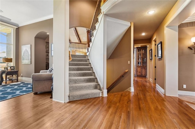 10233 N Prospect Ave, Kansas City, MO 64155 - entrance foyer with arched walkways, wood finished floors, baseboards, stairway, and recessed lighting