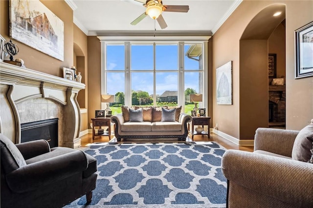 10233 N Prospect Ave, Kansas City, MO 64155 - living area with a tile fireplace, ornamental molding, baseboards, ceiling fan, and wood finished floors