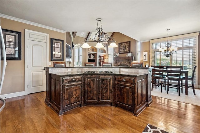10233 N Prospect Ave, Kansas City, MO 64155 - kitchen featuring a chandelier, wood finished floors, gas stovetop, dark brown cabinetry, and ornamental molding